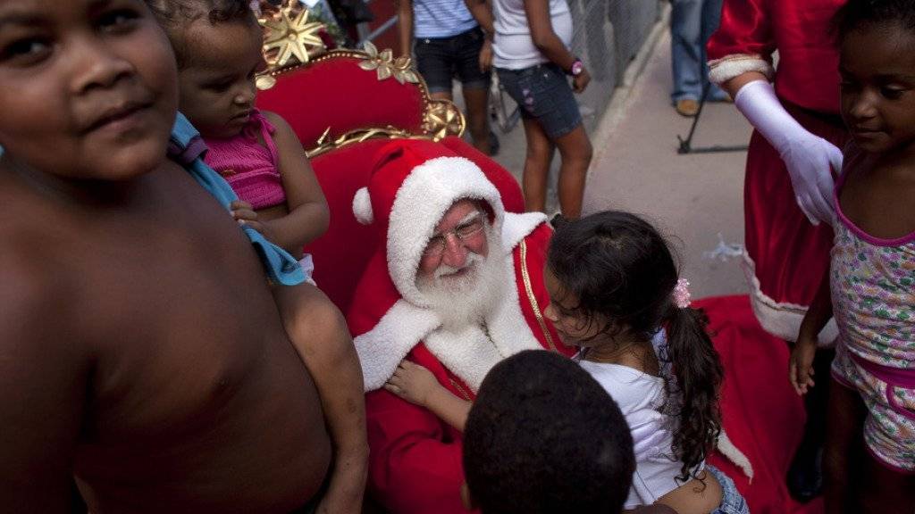 Ein von einer Bank gesponserter Weihnachtsmann spricht in einem Slum in Rio de Janeiro mit Kindern. Wegen der Wirtschaftskrise zögern dieses Jahr viele Geschäfte in Brasilien, einen Weihnachtsmann für ihre Kunden einzustellen (Archiv)
