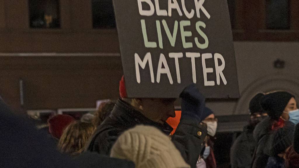 Ein Demonstrant hält ein Schild mit der Aufschrift «Black Lives Matter» während eines Protestmarsches gegen den Freispruch von Kyle R. hoch. Der Angeklagte ist in dem viel beachteten Prozess um den gewaltsamen Tod von zwei Menschen bei Anti-Rassismus-Protesten im vergangenen Jahr freigesprochen worden. Foto: Ron Adar/SOPA Images via ZUMA Press Wire/dpa
