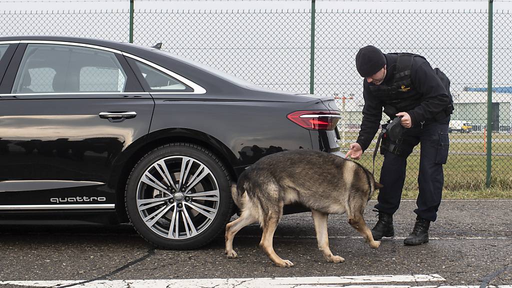 Die Zürcher Regierung fordert mehr Geld für ausserkantonale Polizeieinsätze, etwa am WEF. Im Bild ein Zürcher Kantonspolizist, der mit seinem Diensthund das Auto eines WEF-Teilnehmers untersucht. (Archivbild)