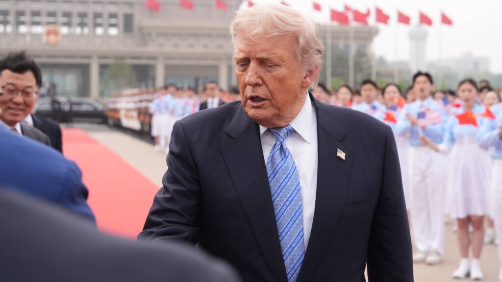 US-Präsident Donald Trump wird vor dem Einsteigen in die Air Force One am Beijing Capital International Airport von Beamten begrüßt. Foto: Mark Schiefelbein/AP/dpa