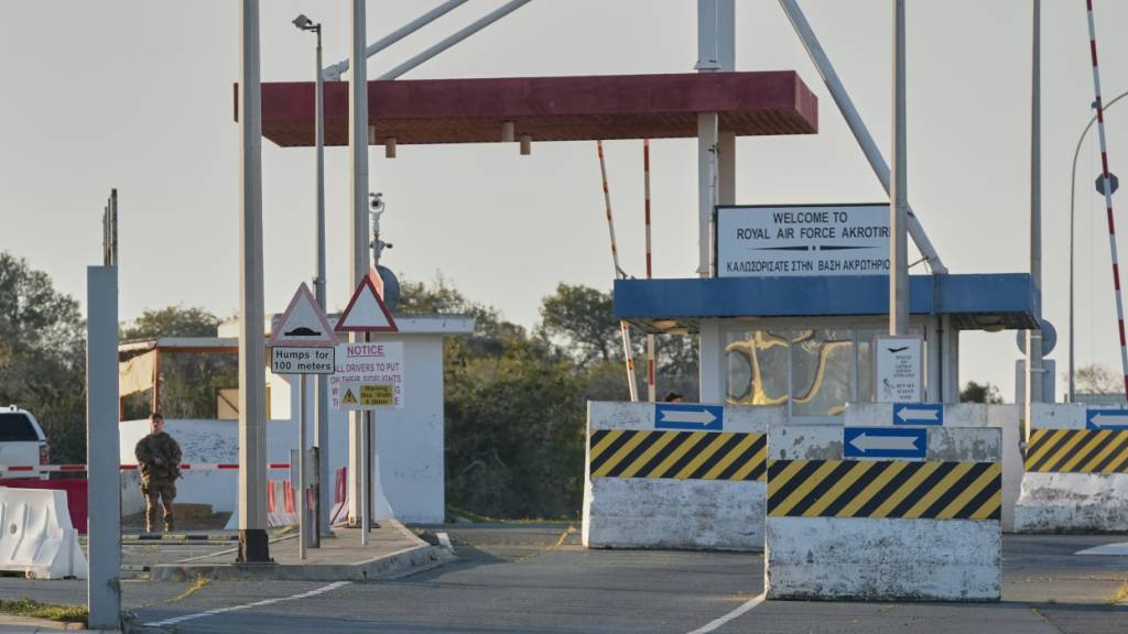 dpatopbilder - Ein britischer Soldat steht am Haupttor des britischen RAF-Stützpunkts Akrotiri Wache, nachdem dieser am frühen Morgen von einem mutmaßlichen Drohnenangriff getroffen worden war. Foto: Petros Karadjias/AP/dpa