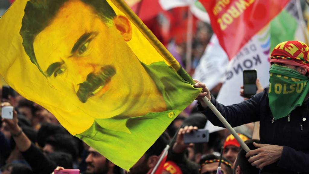ARCHIV - Ein Jugendlicher hält eine Fahne mit dem Bild des inhaftierten Anführers der verbotenen kurdischen Arbeiterpartei PKK, Öcalan. Foto: Lefteris Pitarakis/AP/dpa/Archivbild