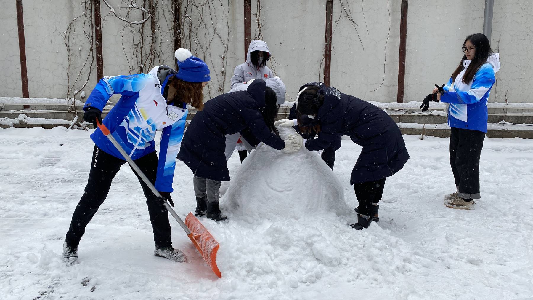 Ein paar Einheimische bauen einen Schneemann.