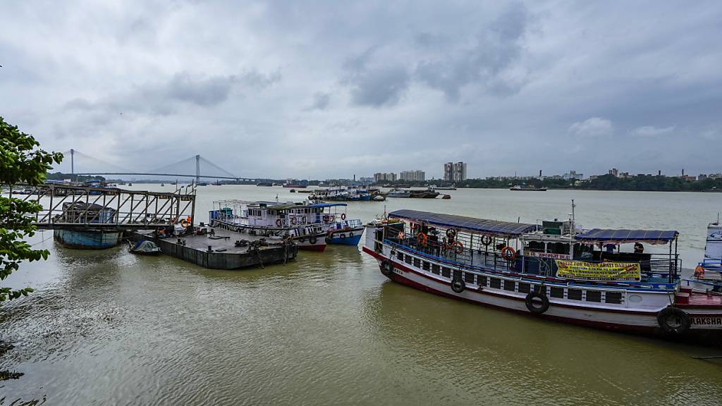 Boote liegen auf dem Hooghly-Fluss vor Anker, nachdem der Fährverkehr wegen des herannahenden Tropensturms «Dana» eingestellt wurde, der nach Angaben des indischen Wetterdienstes am späten Donnerstag und zu Beginn des Freitags in Kolkata, Indien, auf Land treffen soll. Foto: Bikas Das/AP