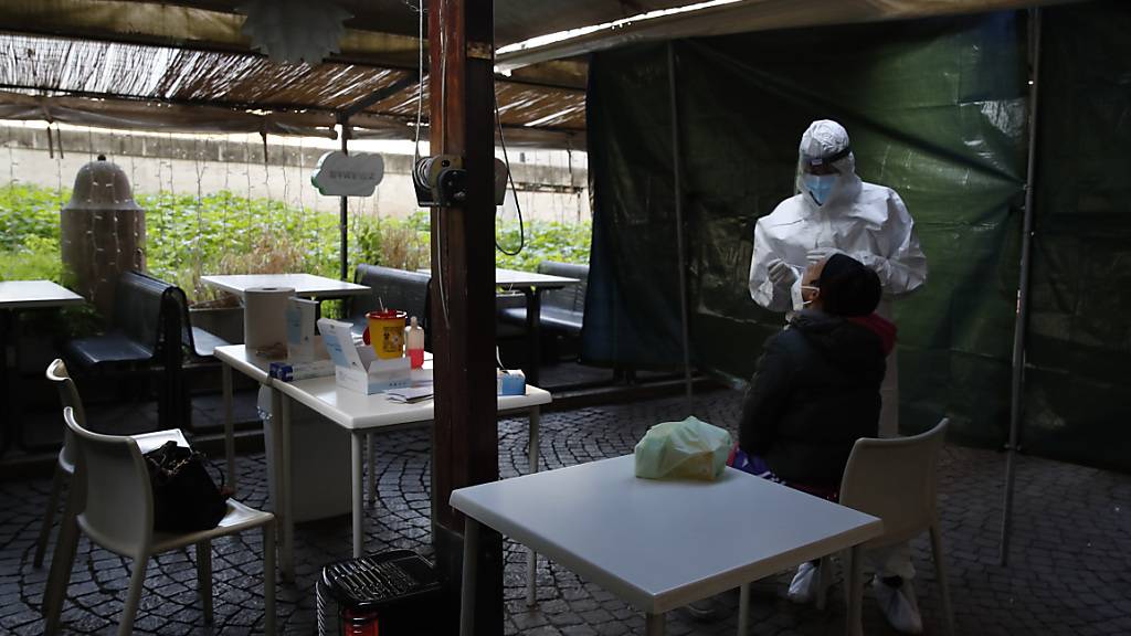 Eine Frau wird im Außenbereich eines geschlossenen Restaurants auf das Coronavirus getestet. Foto: Alessandra Tarantino/AP/dpa