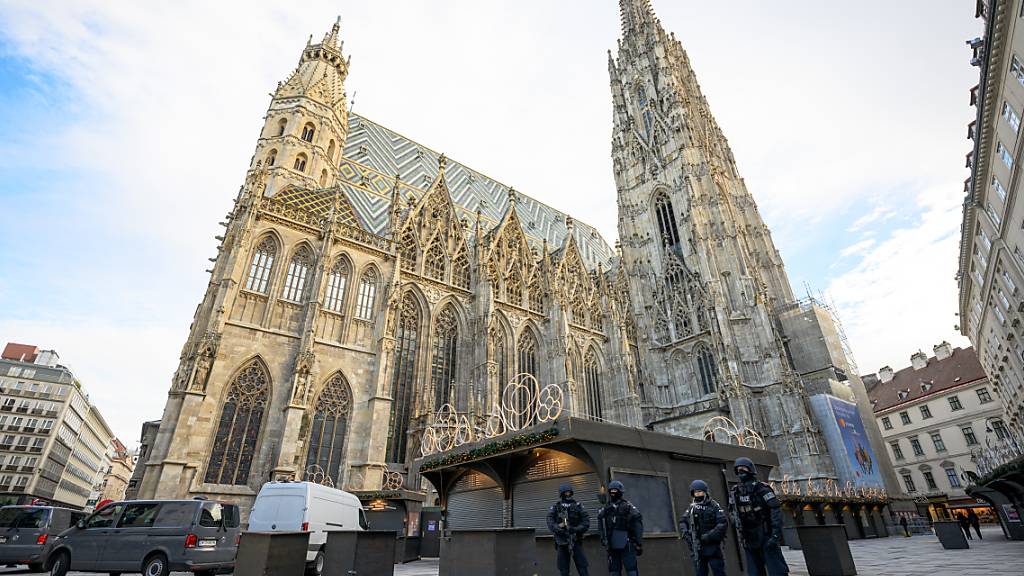 Polizisten stehen nach Hinweisen auf einen möglichen Anschlagsplan einer islamistischen Gruppe vor der Domkirche St. Stephan. Foto: Max Slovencik/APA/dpa