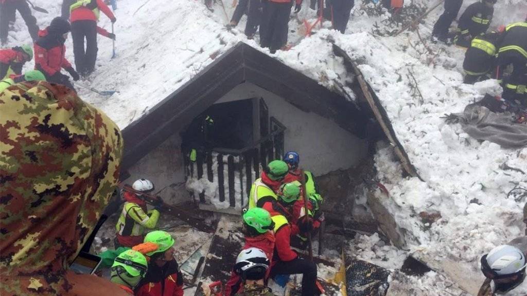 Helferinnen und Helfer suchen in den Trümmern des Hotels nach Überlebenden.