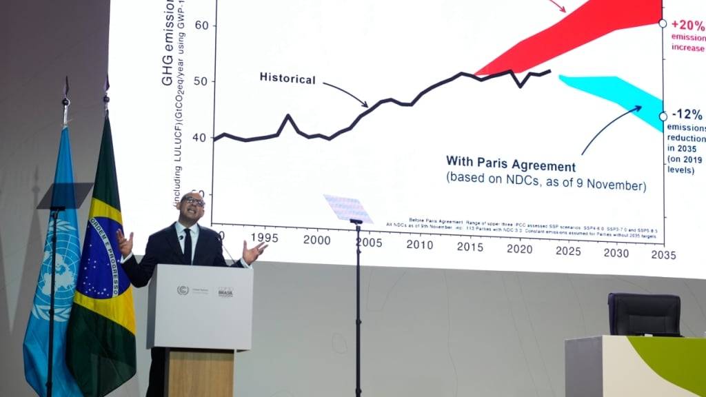 Simon Stiell, UN-Klimachef, spricht während einer Plenarsitzung vor einer Grafik zum Pariser Abkommen auf der Weltklimakonferenz COP30. Foto: Fernando Llano/AP/dpa