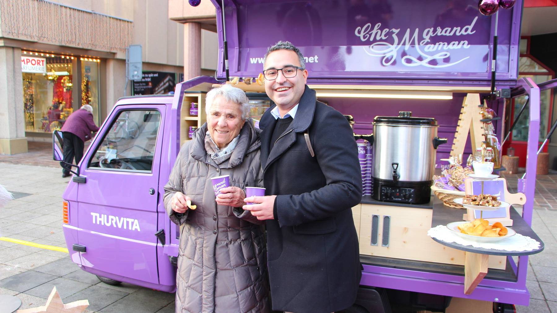Milly Haug und Andreas Bucher stossen auf dem Wiler Weihnachtsmarkt auf den neuen grell-violette Ape an.