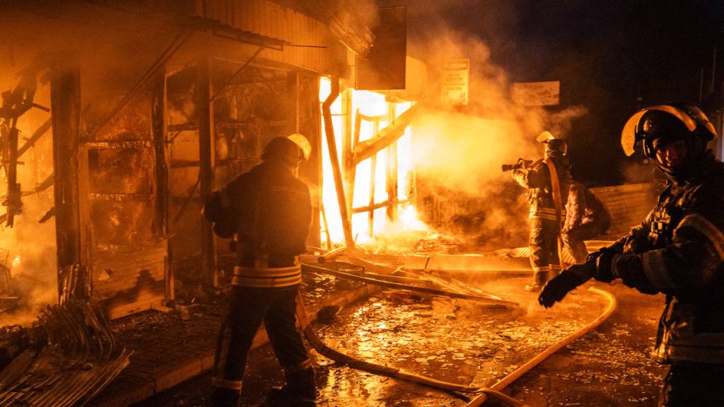 Feuerwehrleute arbeiten daran, die Flammen einzudämmen, die aus dem zentralen Markt in Kramatorsk aufsteigen, nachdem ein russischer Drohnenangriff das Gebiet in Brand gesetzt hat. Foto: Tommaso Fumagalli/ZUMA Press Wire/dpa