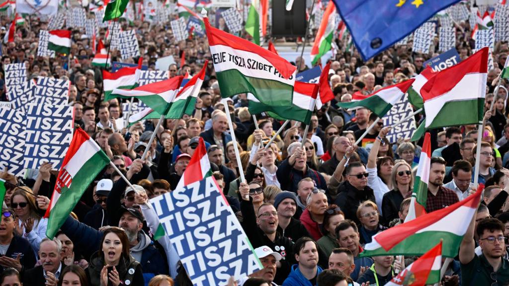 Menschen jubeln, während der Oppositionsführer Magyar bei einer Demonstration eine Rede hält. Foto: Denes Erdos/AP/dpa