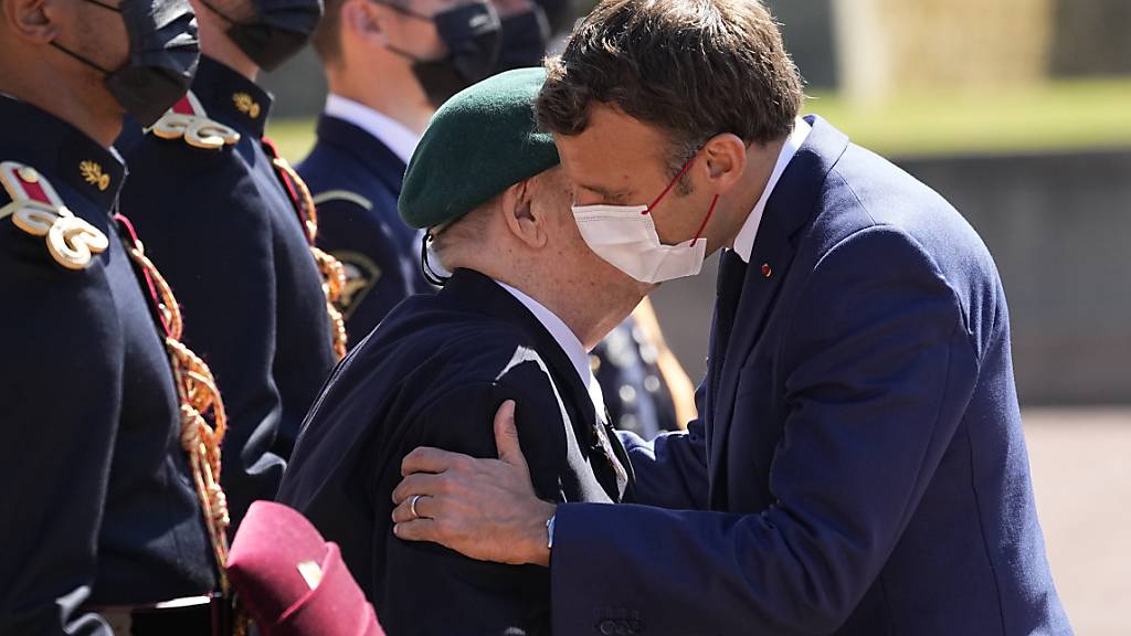 Emmanuel Macron, Präsident von Frankreich, küsst Leon Gautier (r.), 98-jähriger französischer Veteran des Zweiten Weltkriegs und letzter Überlebender des Kieffer-Kommandos, bei einer Feier in der Gedenkstätte Mont-Valérien bei Paris auf die Wange. Foto: Michel Euler/AP POOL/AP/dpa