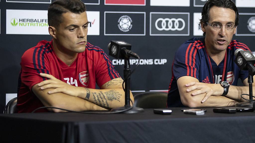 Arsenals Granit Xhaka sitzt an einer Pressekonferenz neben Trainer Unai Emery