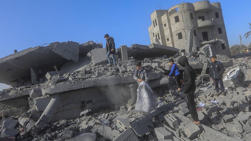 Kinder inspizieren die Trümmer von zerstörten Gebäuden nach israelischem Bombardement. Foto: Mohammed Talatene/dpa