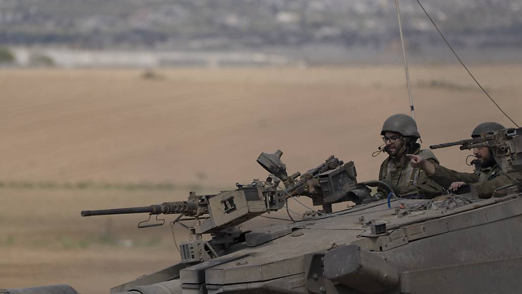 dpatopbilder - Israelische Soldaten fahren auf einem Panzer nahe der Grenze zwischen Israel und Gaza. Foto: Leo Correa/AP/dpa