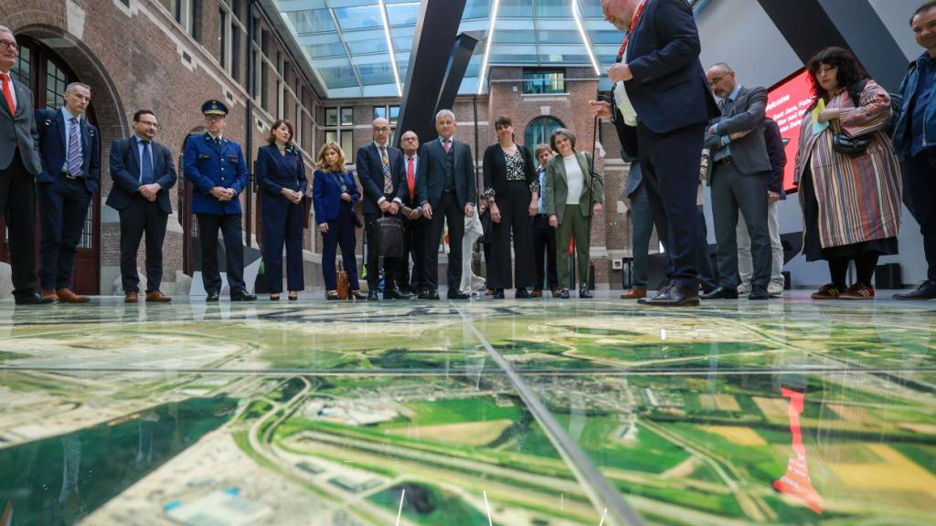 Bundesrat Beat Jans (hinten, in der Mitte) lässt sich vor einer rund 50 Quadratmeter grossen Luftbildaufnahme das Hafengelände von Antwerpen zeigen.