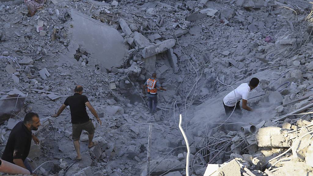 Palästinenser suchen nach Leichen und Überlebenden in den Trümmern eines Wohnhauses, das bei einem israelischen Luftangriff zerstört wurde. Foto: Jehad Alshrafi/AP/dpa