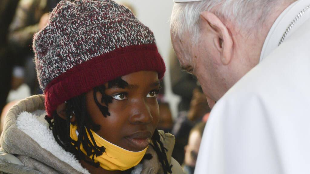 Papst Franziskus (r) spricht während seines Besuchs im Migrantenlager Camp Kara Tepe mit einem Mädchen.