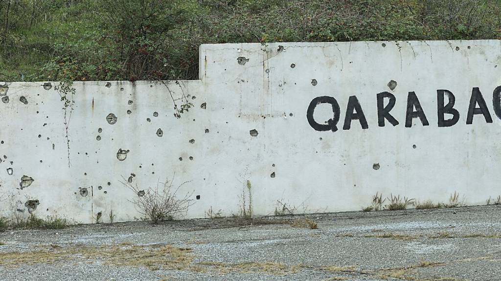 Eine Wand mit Einschusslöcher und einem Graffito in Stepanakert in Berg-Karabach. Foto: Aziz Karimov/AP/dpa