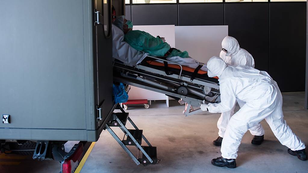 Das Tessin ist landesweit am stärksten vom Coronavirus betroffen: Soldaten der Schweizer Armee beim Transport eines Patienten mit Covid-19 am Eingang der Notaufnahme im Kantonsspital ‹‹La Carita›› in Locarno.