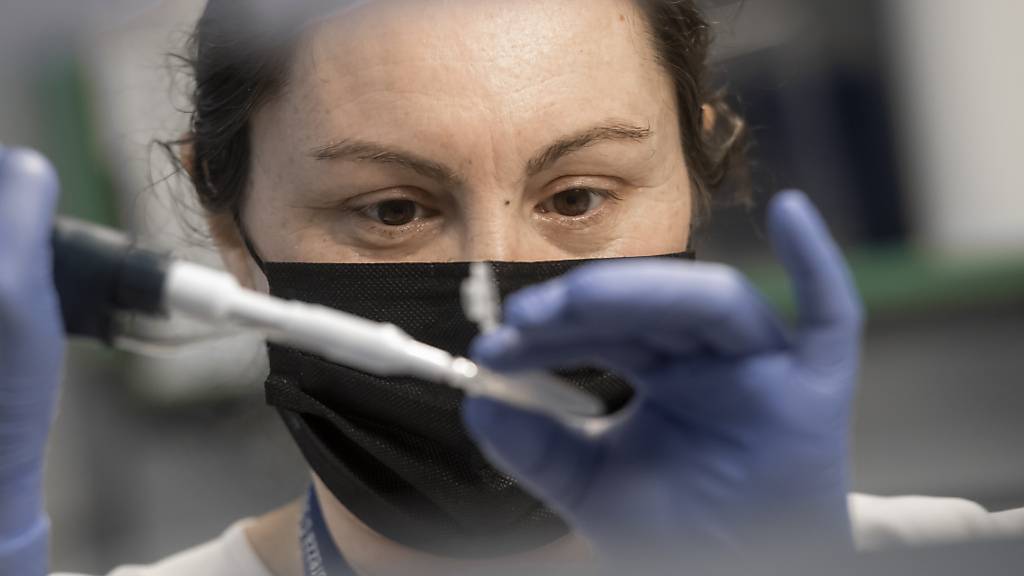 Eine Laborantin in Bellinzona bereitet eine Probe mit extrahierter RNA für einen PCR-Test vor, bei denen Mutationen des Coronavirus erkannt werden sollen. (Archivbild)