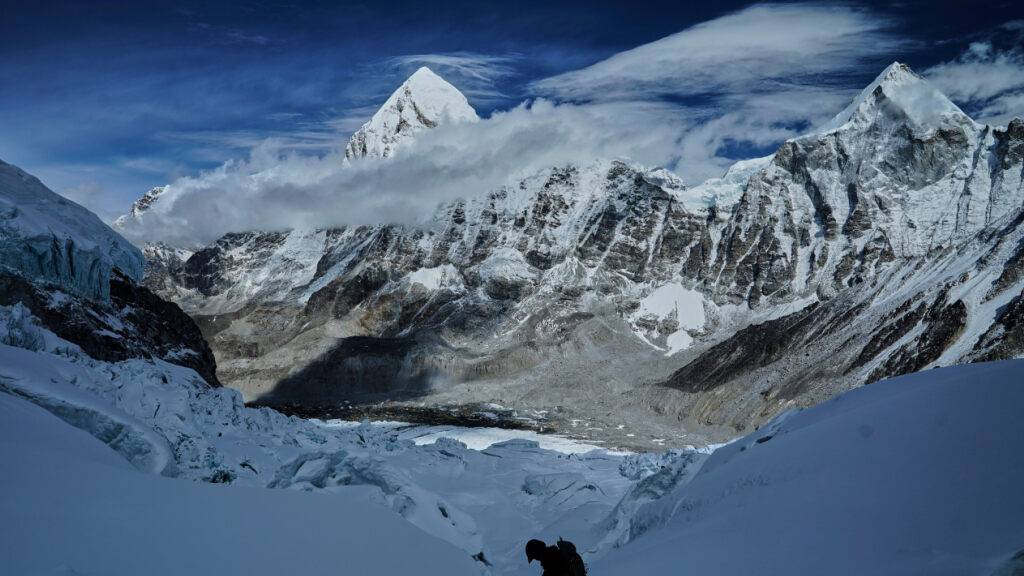 ARCHIV - Der Berg Pumori (Mitte l) ragt im Hintergrund auf, während ein Bergsteiger den Khumbu-Eisfall durchquert, um zum Everest-Basislager abzusteigen. Foto: Pasang Rinzee Sherpa/AP/dpa (Archivbild)