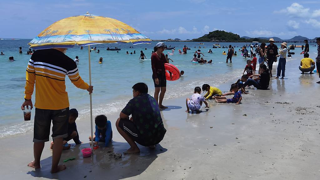 Menschen geniessen die Zeit am Strand von Chonburi in Thailand.