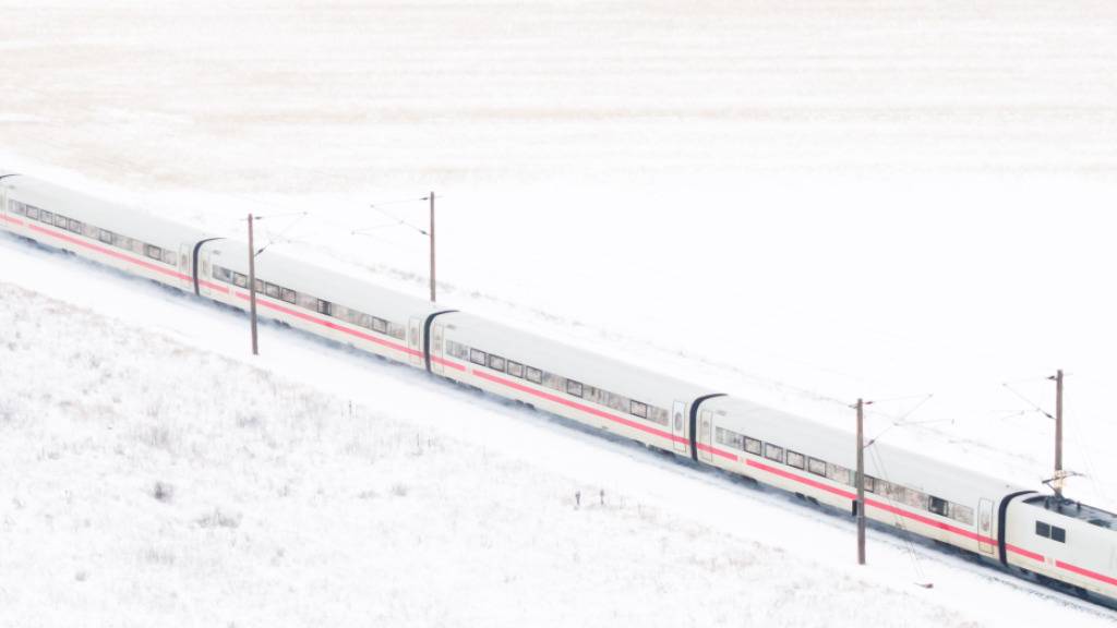 ARCHIV - Ein ICE der Deutschen Bahn in einer Winterlandschaft. Foto: Julian Stratenschulte/dpa/Archivbild