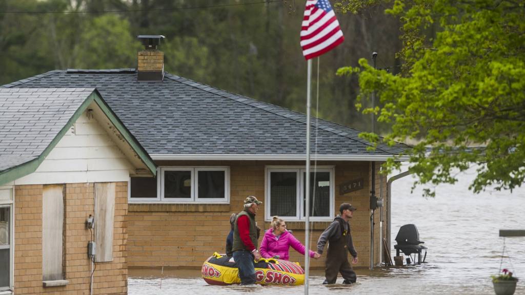 Einwohner in Beaverton im US-Staat Michigan bewegen sich nach Überschwemmungen auf Gummibooten vorwärts.