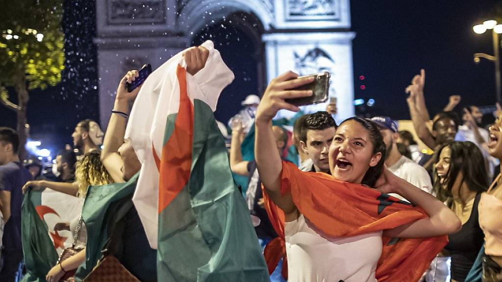 Ausgelassener Jubel: Algerische Fussballfans feiern vor dem Arc de Triomphe in Paris
