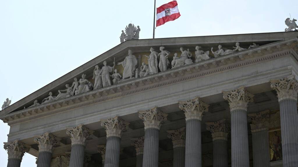 Die österreichische Fahne hängt auf Halbmast am Parlament. Ein 21-Jähriger aus dem Raum Graz hat nach Angaben der Behörden die tödlichen Schüsse an einem Gymnasium im österreichischen Graz abgegeben. Am Vormittag hatte der Mann neun Menschen getötet und danach Suizid begangen. Foto: Helmut Fohringer/APA/dpa