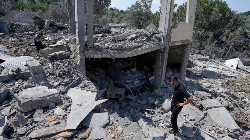 Menschen untersuchen die Trümmer eines zerstörten Hauses im Südlibanon. Foto: Mohammed Zaatari/AP/dpa/Archivbild