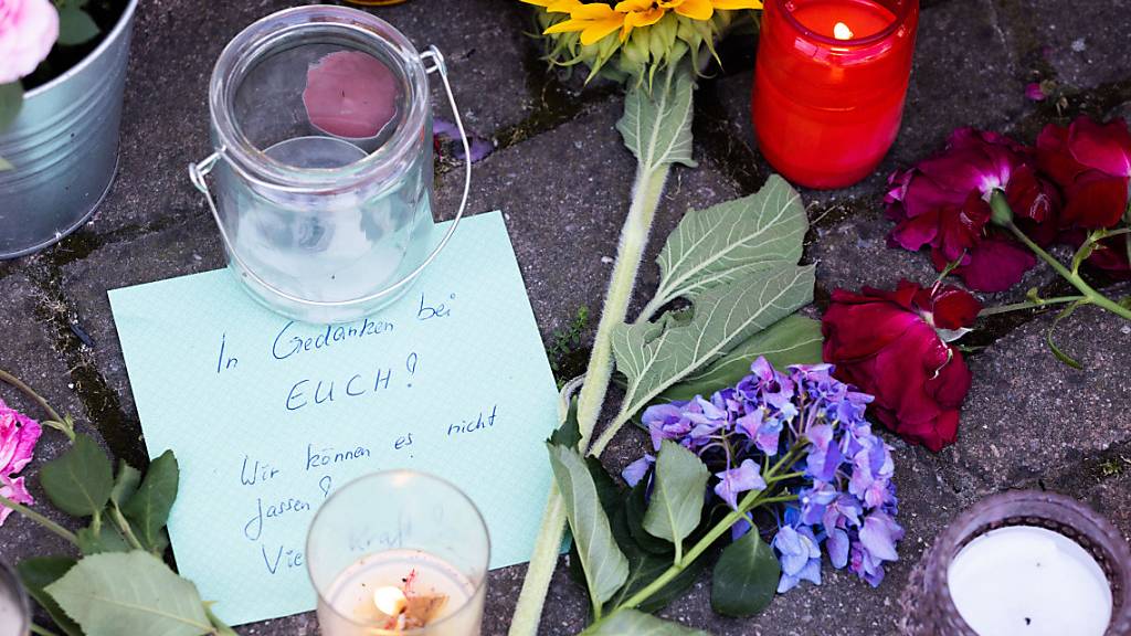 Blumen, Kerzen und Botschaften liegen vor dem Rathaus von Gottenheim, wo Menschen sie in Anteilnahme am Tod einer 14-jährigen abgelegt haben. Foto: Philipp von Ditfurth/dpa