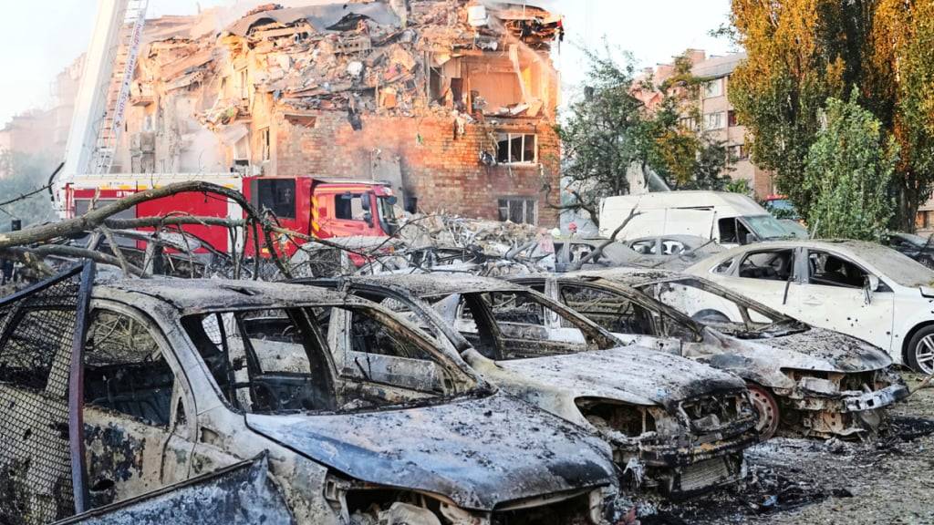 Feuerwehrleute arbeiten an einem brennenden Gebäude nach einem russischen Angriff. Foto: Efrem Lukatsky/AP/dpa