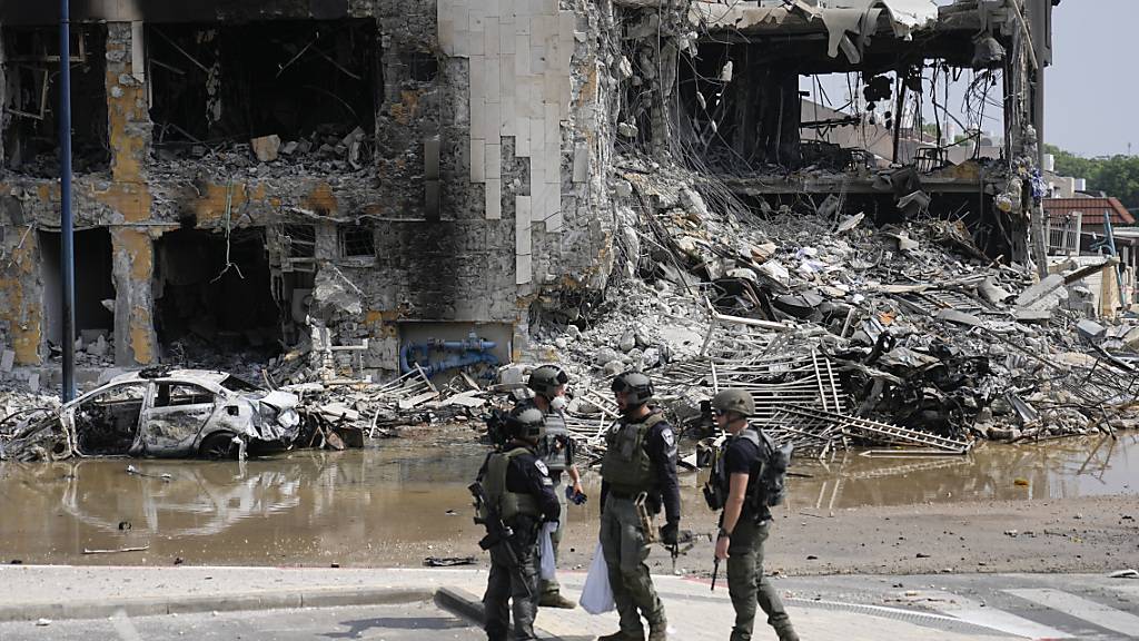 Israelische Polizisten stehen vor einer zerstörten Polizeistation. Foto: Ohad Zwigenberg/AP/dpa