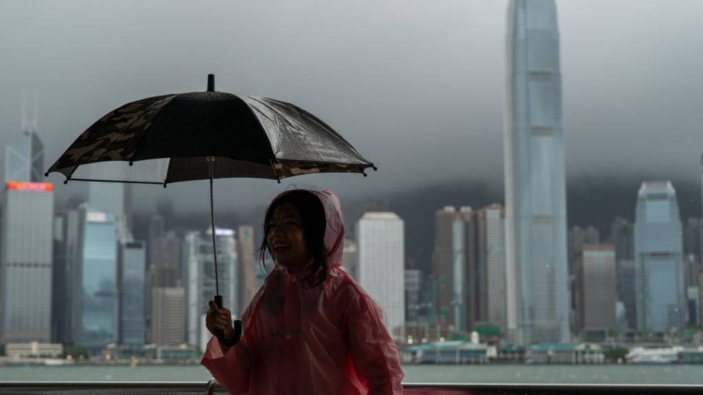 ARCHIV - Ein Mädchen hält einen Regenschirm in Tsim Sha Tusi vor dem Victoria Harbor und der Skyline von Hongkong während des Taifuns «Tapah». Foto: Vernon Yuen/Nexpher via ZUMA Press Wire/dpa (Archivbild)