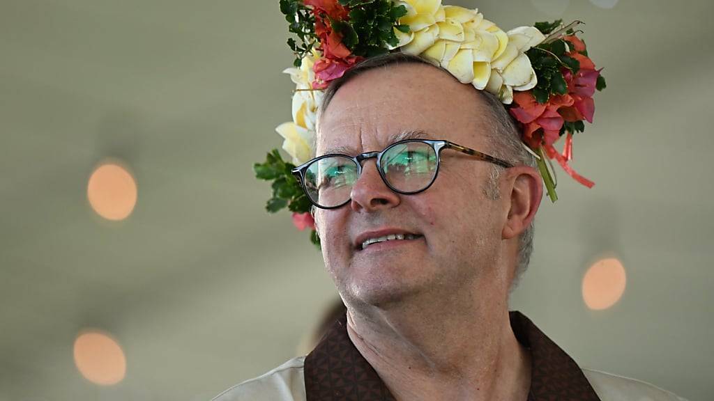 Der australische Premierminister Anthony Albanese trägt bei der Unterzeichnung des Abkommens mit Tuvalu einen geblümten Kopfschmuck. Foto: Lukas Coch/AAP/dpa