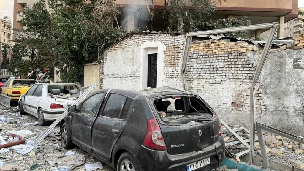 Trümmer eines Wohnhauses liegen auf geparkten Autos nach einem Angriff in Teheran. Foto: Vahid Salemi/AP/dpa