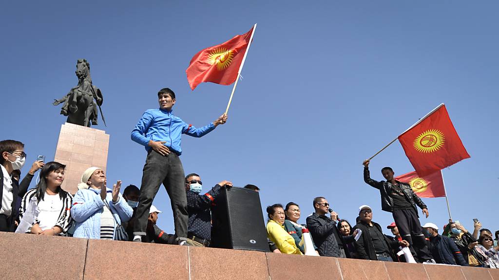 Menschen protestieren während einer Kundgebung gegen die Ergebnisse einer Parlamentsabstimmung. Nach der Parlamentswahl in dem zentralasiatischen Land Kirgistan ist es zu Ausschreitungen mit der Polizei gekommen. Foto: Vladimir Voronin/AP/dpa