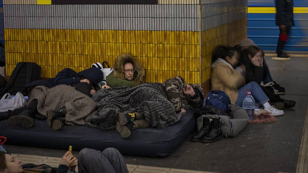 dpatopbilder - Menschen schlafen in einer U-Bahn-Station in Kiew, die als Luftschutzbunker genutzt wird. Foto: Emilio Morenatti/AP/dpa