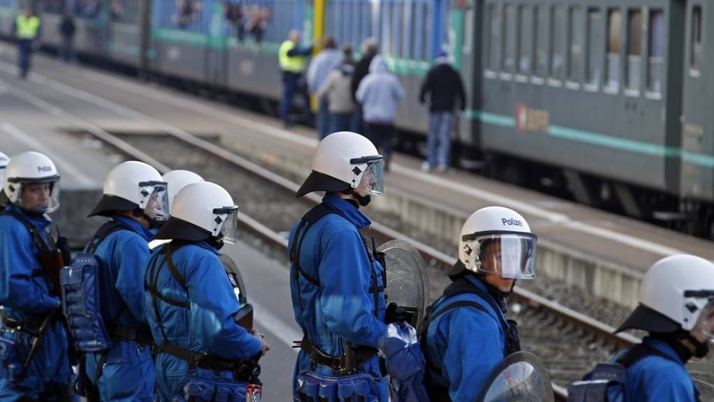 Polizisten bewachen am Bahnhof Zürich-Altstetten einen Zug mit FC-Basel-Fans. (Archivbild)