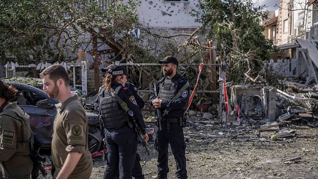 Israelische Sicherheitskräfte stehen vor beschädigten Gebäuden nach einem angeblichen Angriff der pro-iranischen Hisbollah-Bewegung. Foto: Ilia Yefimovich/dpa