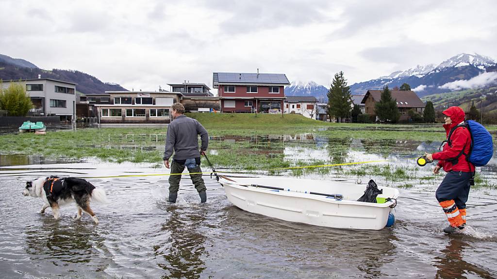 Quartierbewohnende des Quartiers Ried in Sachseln paddeln während des Hochwassers mit ihrem Boot zu ihrer Wohnung. (Archivbild)