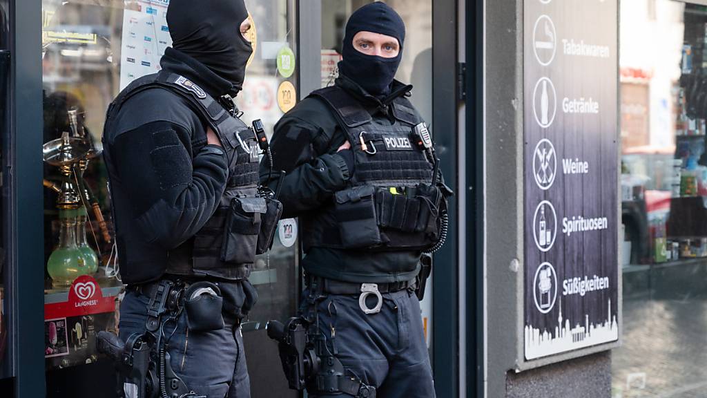 Polizisten stehen bei einer Razzia vor einem Spätkauf in Neukölln. Mit einer Großrazzia ist die Polizei am Donnerstag gegen Clankriminalität in Berlin und Umgebung vorgegangen. Foto: Christophe Gateau/dpa