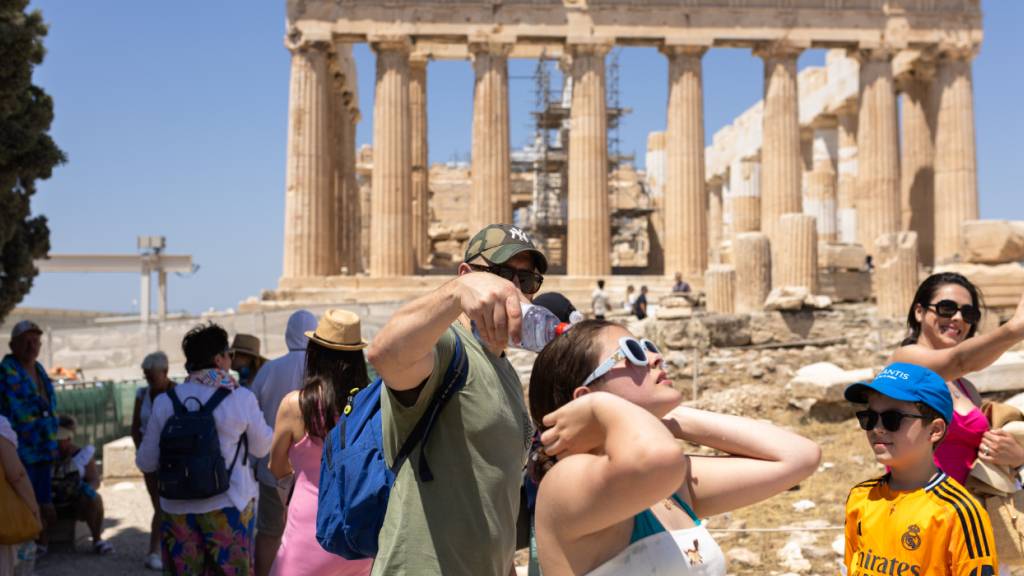 ARCHIV - Touristen gehen über das Gelände der Akropolis. Foto: Socrates Baltagiannis/dpa