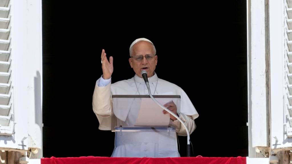 Papst Leo XIV. erteilt seinen Segen, während er das Angelus-Mittagsgebet von einem Fenster mit Blick auf den Petersplatz im Vatikan spricht. Foto: Andrew Medichini/AP/dpa