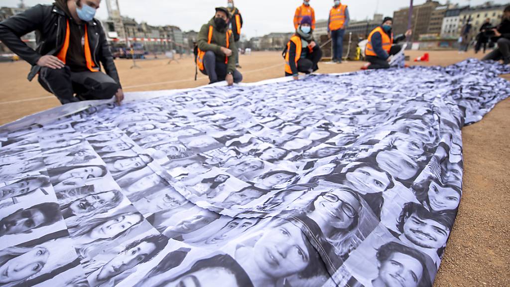 Die «We are watching»-Fahne setzt sich aus Tausenden von Porträts aus aller Welt zusamen. Quelle: KEYSTONE Fotograf: MARTIAL TREZZINI