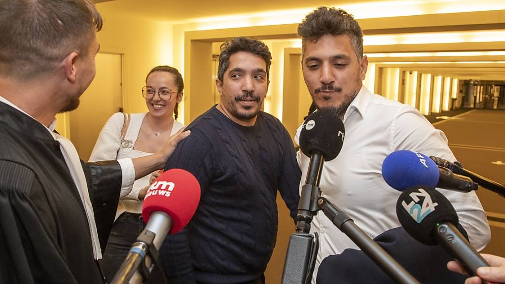 Rechtsanwalt Michel Degreve (l-r) und die Angeklagten Smail F. Ibrahim F. sprechen mit Journalisten, nachdem die beiden für unschuldig erklärt wurden. Foto: Nicolas Maeterlinck/Belga/dpa