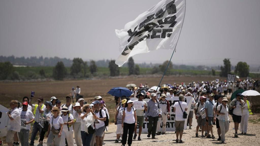 Friedensaktivisten marschieren in der Nähe der Grenze zwischen Israel und Gaza. Foto: Leo Correa/AP/dpa