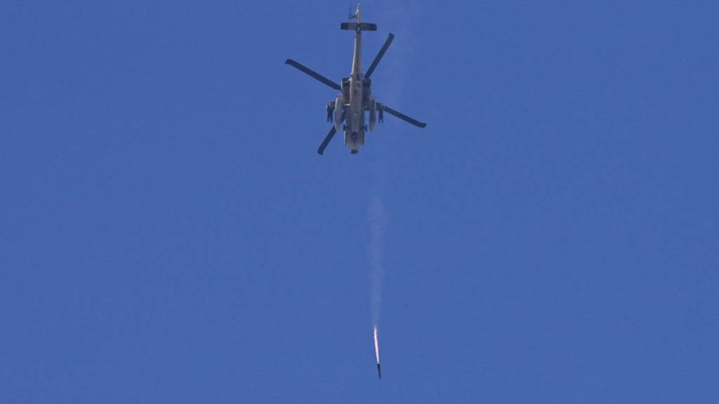 Ein israelischer Apache-Hubschrauber feuert eine Rakete in Richtung des Gazastreifens ab, gesehen vom Süden Israels aus. Foto: Ohad Zwigenberg/AP/dpa